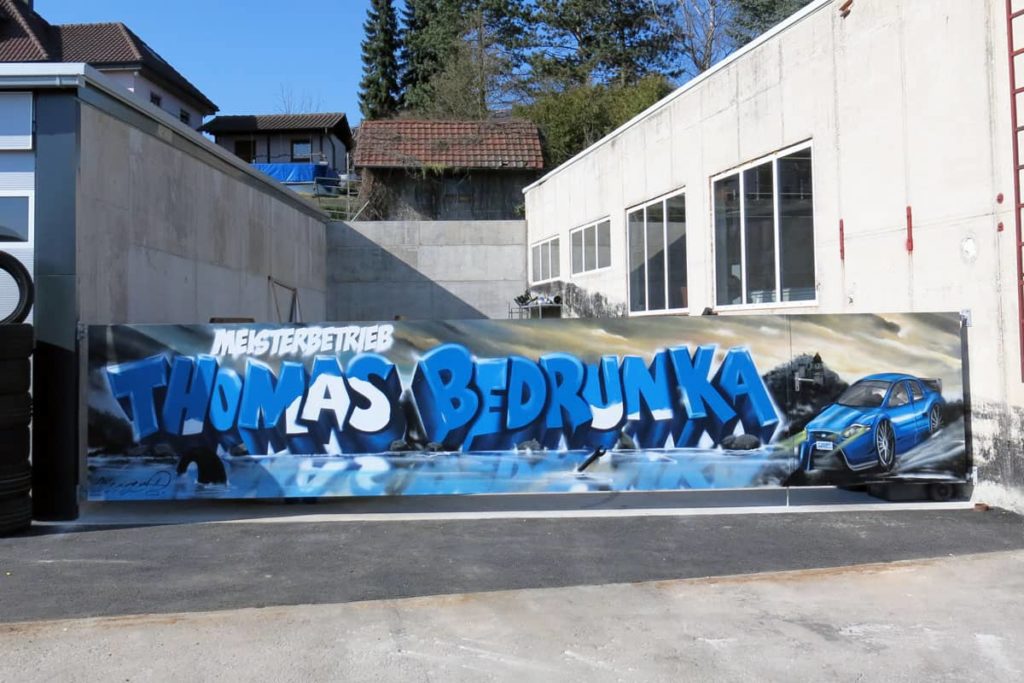 Graffiti Außengestaltung für die Autofit Werkstatt  Thomas Bedrunka in Herrenberg. Jan bemalte das Tor mit dem Firmen Schriftzug.