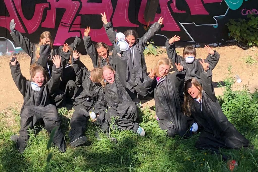 Um den Graffiti Kindergeburtstag von Alona gebührend zu feiern, haben wir von Graffiti Stuttgart mit ihren Gästen ein cooles Graffiti an der Außenwand vom Camp Feuerbach gemalt. Am Tag der Malaktion grundierte Micha die zu besprühende Fläche mit Wandfarbe, um dann die zuvor verabredeten Motive auf der Betonmauer vor zu skizzieren. Anschließend malte Alona mit ihren Freunden den Graffiti Style mit allen Buchstaben und Elementen farbig aus. Danach sprühte Micha noch die Konturen Outlines und die Lichteffekte.