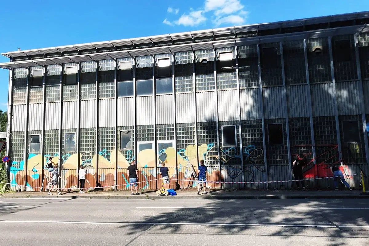 Teilnehmende sprühen den Schriftzug „Solidarität" an eine Hallenwand in Aalen