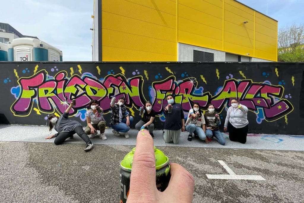 Schoettle-Schule Für die Schüler der Helene-Schoettle-Schule haben wir ein coolen Graffiti Ausflug organisiert. Unter Anleitung von Chris und Patrick sprühten die TeilnehmerInnen den Schriftzug „Frieden für alle„.