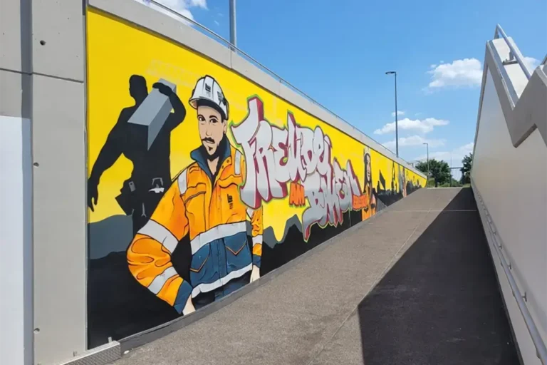 Kunst und Bau vereint – in Satteldorf wurde eine Straßenunterführung mit einem beeindruckenden Graffiti-Design verschönert, das die Freude am Bauen kreativ darstellt.