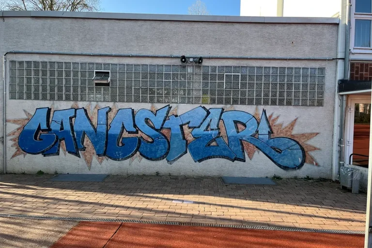 Buntes Graffiti-Wandbild an der Wartbergschule Heilbronn mit Peace-Zeichen, dem Schriftzug WBS, Friedenstaube, Smiley und Herzen.