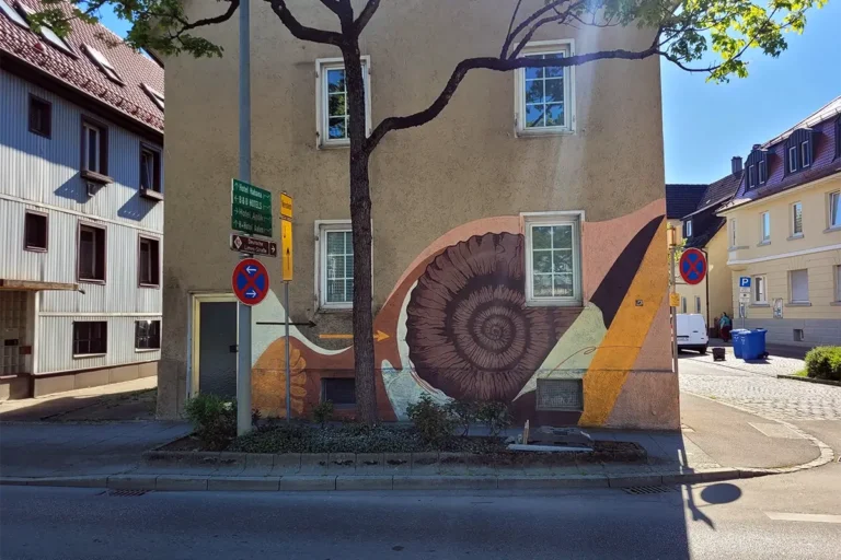 Graffiti-Künstler Chris vor der fertigen Fassadengestaltung an der Julius-Leber-Straße in Aalen