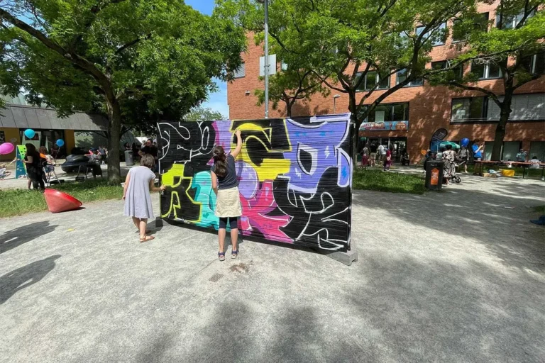Kinder besprühen beim Bürgerfest West in Stuttgart-West eine Wand mit bunten Graffiti-Buchstaben
