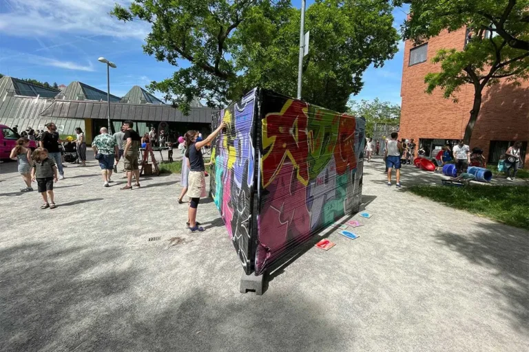 Kinder besprühen beim Bürgerfest West in Stuttgart-West eine Wand mit bunten Graffiti-Buchstaben